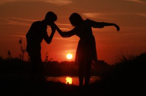 love-couple-kissing-on-hand-at-sunset