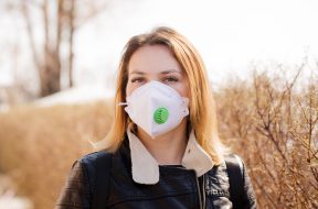 Young woman in a protective mask is walking. Coronavirus Protection Concept