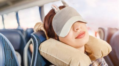 Womang in sleep mask and with pillow travelling in bus