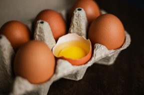 fresh-brown-eggs-broken-egg-with-yolk-eco-tray-made-from-recycled-paper-dark-wooden