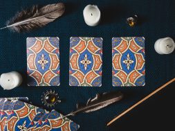 Divination cards, candles and dark background. View from above. Close-up