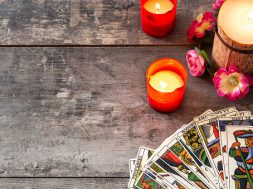 Tarot cards on wooden table with candles