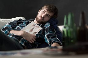 Depressed man drinking beers after split up