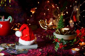 Blurred Tarot cards on table near burning candles. Tarot reader or Fortune teller reading on Christmas decoration