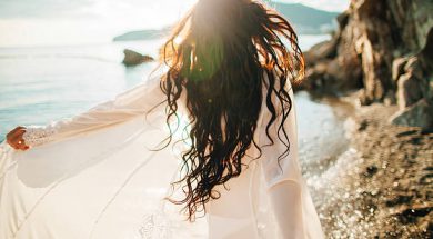 girl running dreamy with wind in hair and sunflare on beach sunset. defocus