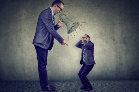 Angry business man boss screaming at himself small in megaphone