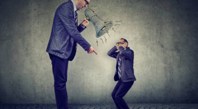 Angry business man boss screaming at himself small in megaphone
