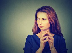 Closeup portrait of sneaky, sly, scheming young woman plotting something isolated on gray background. Negative human emotions, facial expressions, feelings, attitude