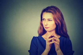 Closeup portrait of sneaky, sly, scheming young woman plotting something isolated on gray background. Negative human emotions, facial expressions, feelings, attitude