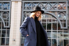 Lifestyle portrait of fashionable woman wearing winter or spring outfit, felt hat, gray wool coat, turtleneck. Outdoors. Female stylish Model smiling, walking city Street. Street fashion trend