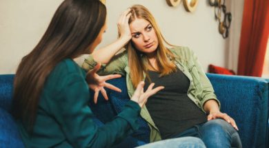 Young woman is sad, she is talking to a friend in cafe.