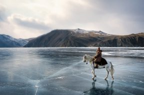 On the shooting of "Serko", a film reenacting the longest horse-ride ever done in the history of man, : 9000 Km in 200 days from the Amur River to St Petersburg, by a Cossack named Dimitri Petchkov and his horse Serko  in the winter of 1890. Siberia, Irkutsk District, Lake Baikal region, March 2005. Director: Joel Farges. Adaptation from the book by Jean-Louis Gouraud: Serko.
Dimitri Petchkov (Actor: Alexei) and horse Serko riding over frozen Lake Baikal.